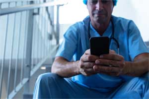 Krankenhausarzt in einer Pause am Smartphone