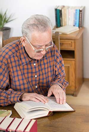 Mann liest Buch in Bibliothek