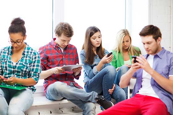 Schüler verwenden Smartphones und Tablets während Schulpause